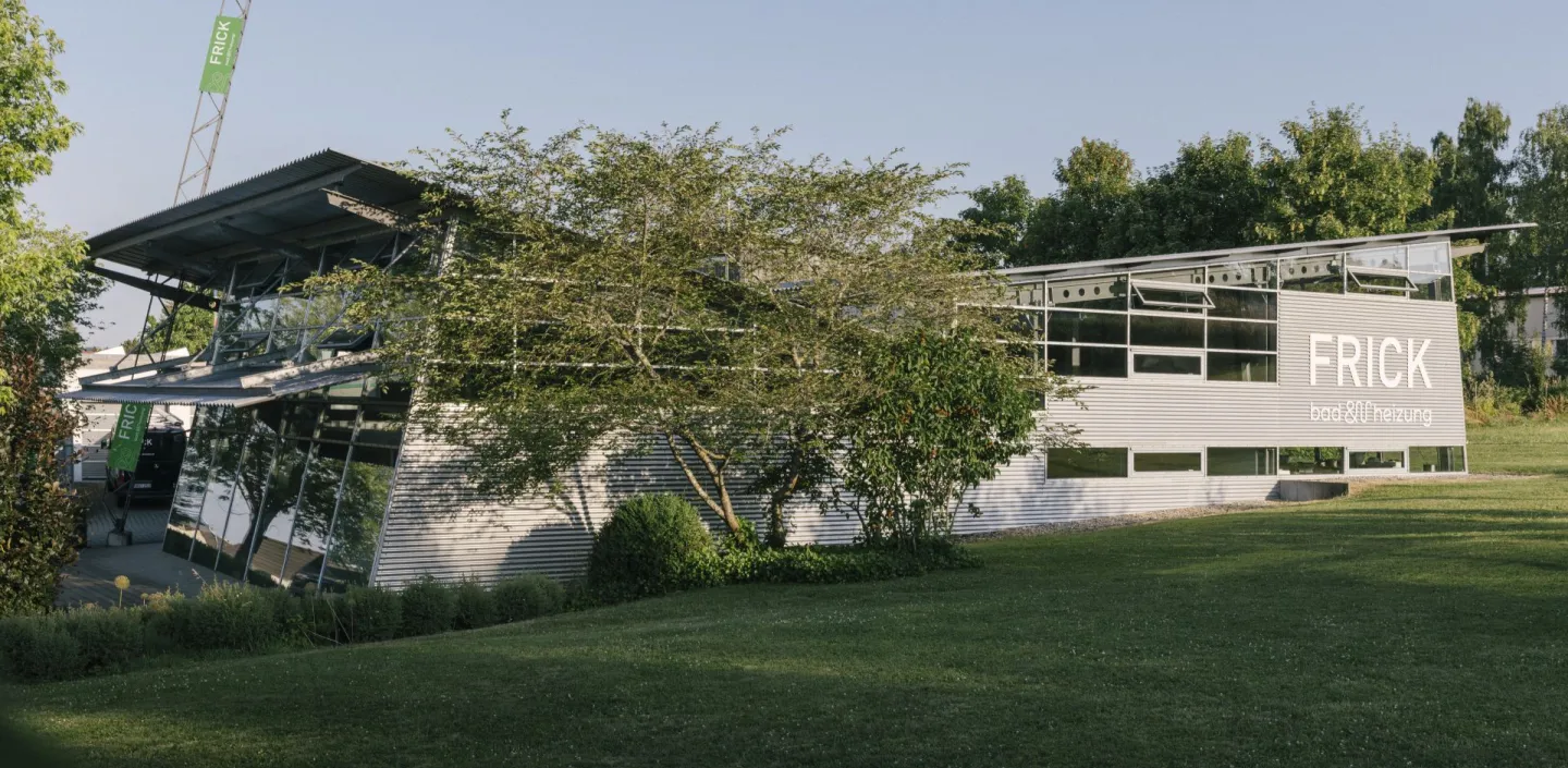 Das Firmengebäude des Familienunternehmens bad und heizung Frick in moderner Architektur umgeben von viel Gruen und Natur.