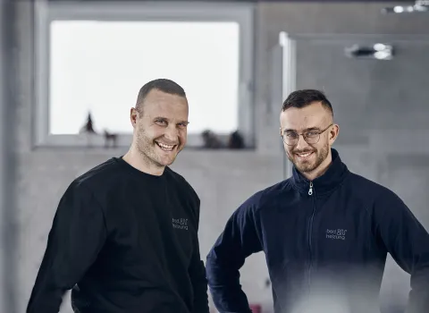 Zwei lachende Azubis von bad & heizung in einem Bad.