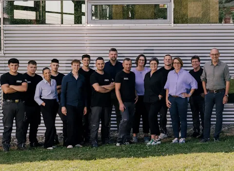 Das team von Frick vor ihrem Firmengebäude