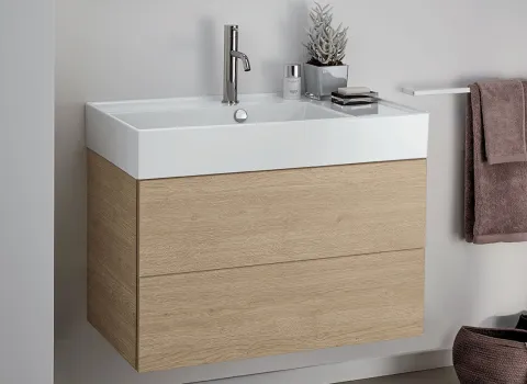 Kompaktes Stocco Badmöbel mit heller Holzoptik, integriertem Waschbecken und weichen Textilakzenten.