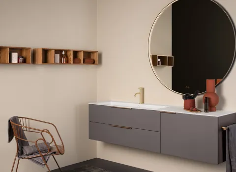 Stocco Badmöbel in Taupe mit rundem Spiegel, goldener Armatur und offenen Wandregalen aus Holz.