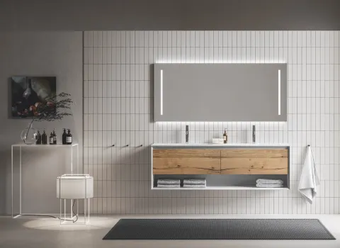 Badezimmer mit Stocco Iks in der Up-Variante mit Leuchtspiegel in hellen Holztönen und Weiß.