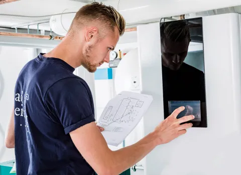 Ein Handwerker vom Kundendienst bedient eine Heizungsanlage.