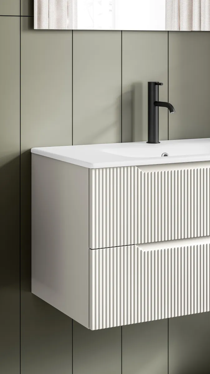 Detailansicht eines wandhängenden Waschtischs mit geriffelter Front in weiß und schwarzer Armatur.