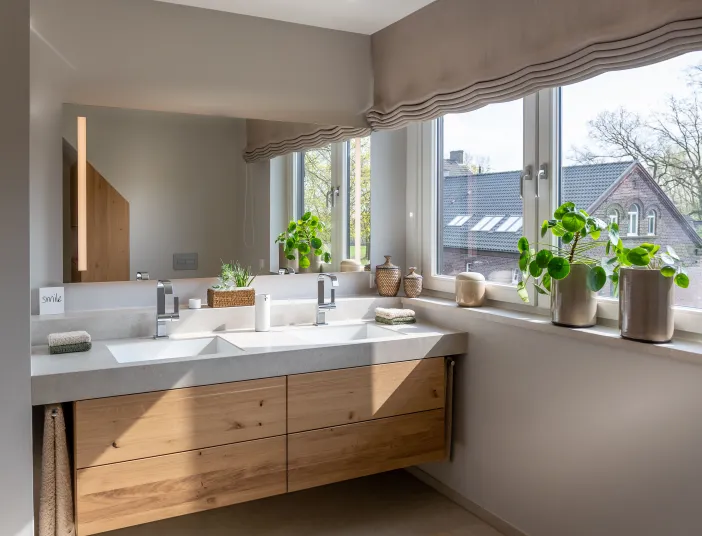 Badezimmer im Landhausstil mit Holzwaschtisch neben Fenster.