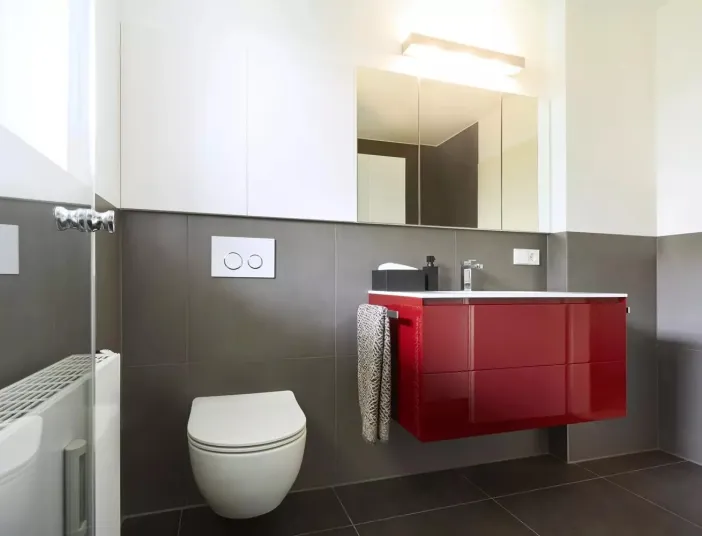 Kleines Platzwunder mit Spiegelschrank und rotem Waschtisch